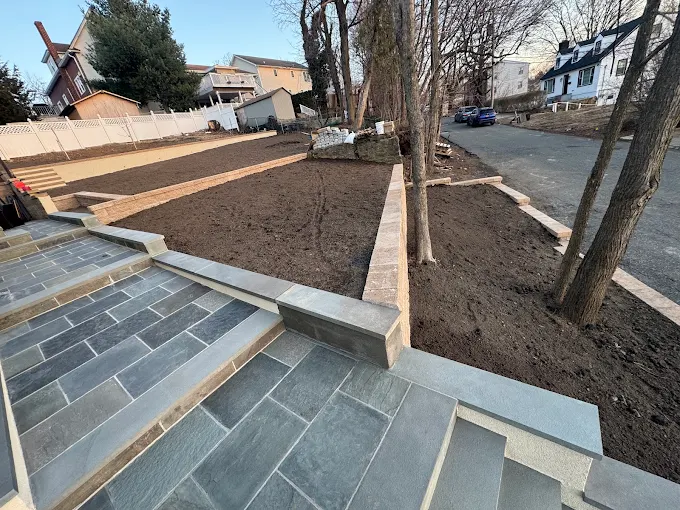 Landscaping project with stone steps and freshly prepared garden beds