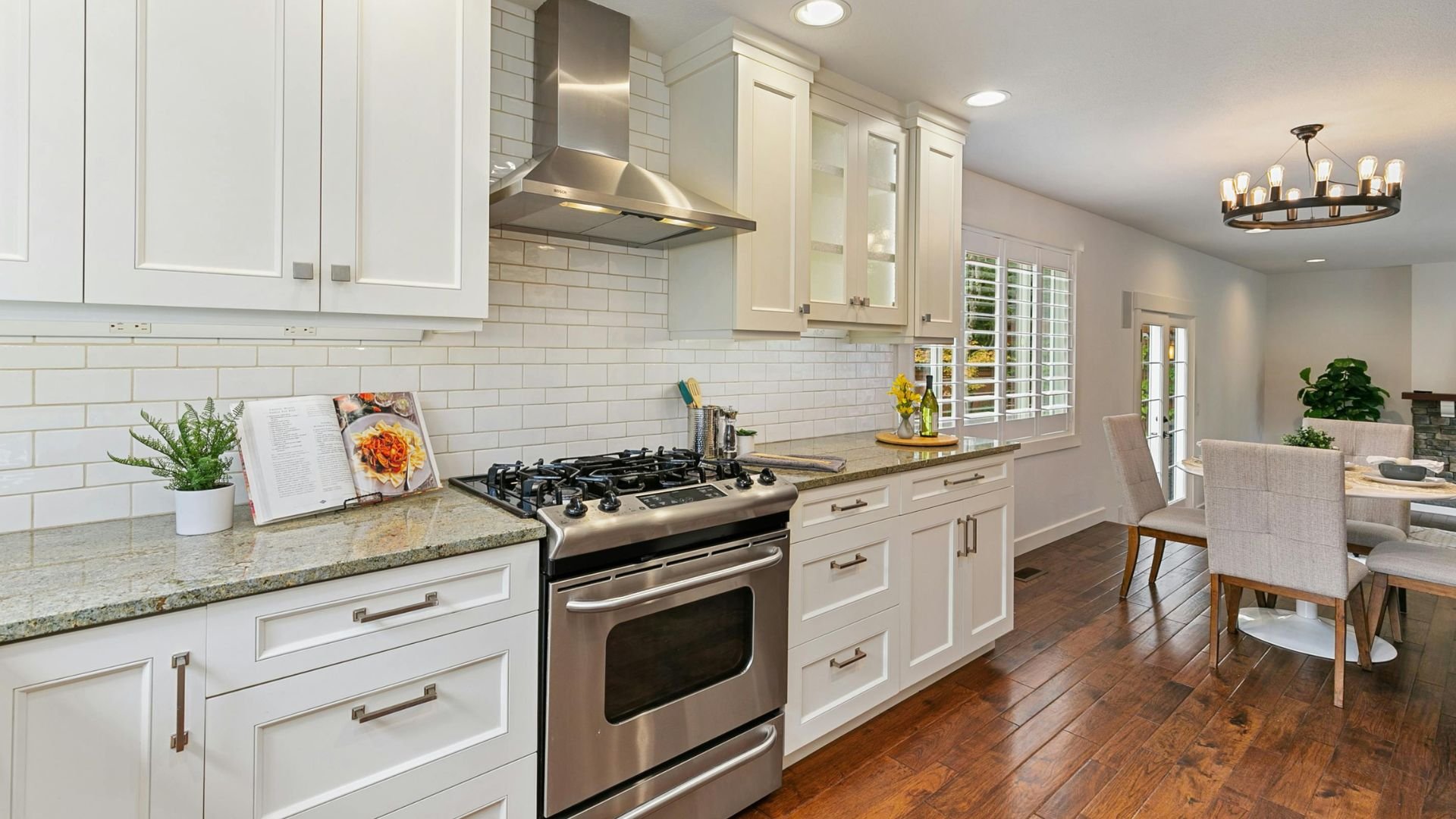 Modern white kitchen with stainless steel appliances and hardwood floors