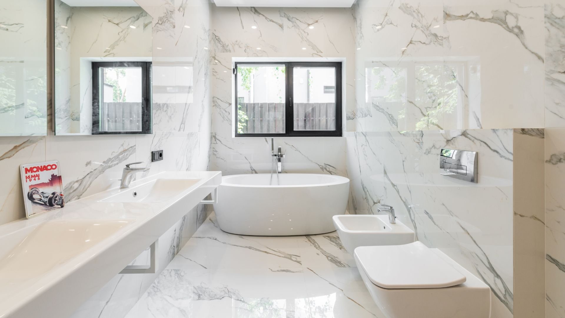 Luxurious marble bathroom with white bathtub, sink, and modern fixtures
